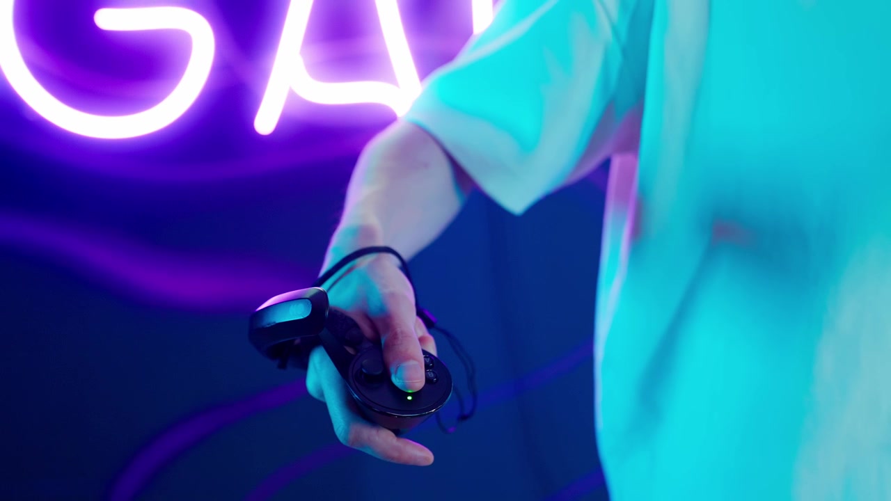 Primo piano di mano che aziona controller VR con luce al neon