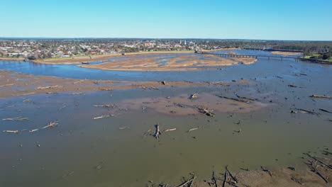 over the dead tress lying in the mud of lake mulwala with the bridge and town of yarrawonga in the background