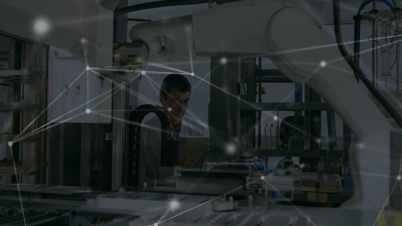 Engineer tapping tablet and initiating digital network linking machines across factory line