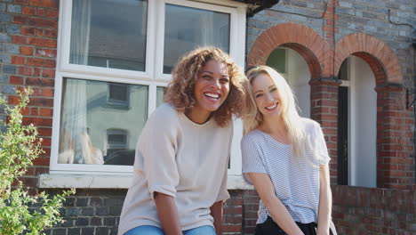 Porträt-Zweier-Frauen,-Die-Vor-Ihrem-Neuen-Zuhause-Stehen-Und-Sich-Gegenseitig-High-Five-Geben