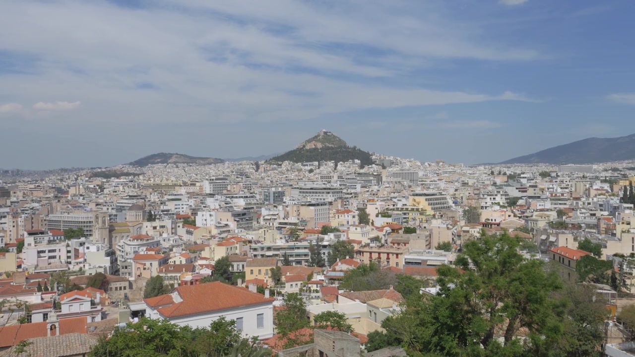 Paesaggio urbano di Atene con il Monte Licabetto sullo sfondo in una giornata di sole con alcune nuvole. Ripresa panoramica