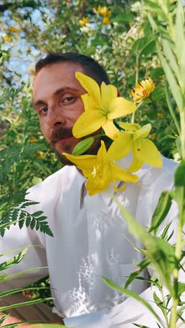 man with yellow flowers in a garden