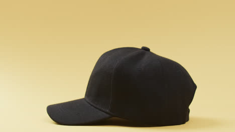 Video-of-black-baseball-cap-and-copy-space-on-yellow-background