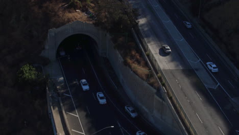 Drone-shot-of-Los-Angeles-Traffic-going-on-a-bridge-and-out-of-a-tunnel