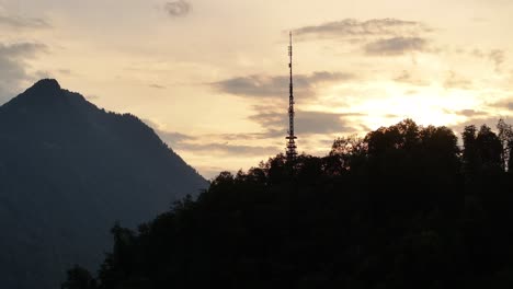 Puesta-De-Sol-Sobre-Una-Montaña-Recortada-Con-Una-Torre-De-Comunicaciones-En-Glaris-Nord,-Suiza