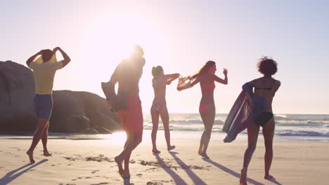 Diverse-Group-of-friends-swimming-in-the-sea-at-sunset