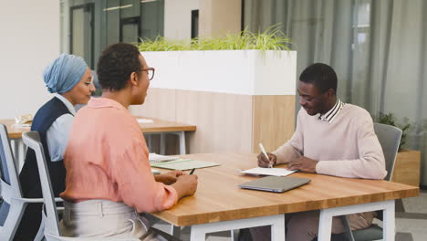 woman answers a question about a document to a young in a job interview