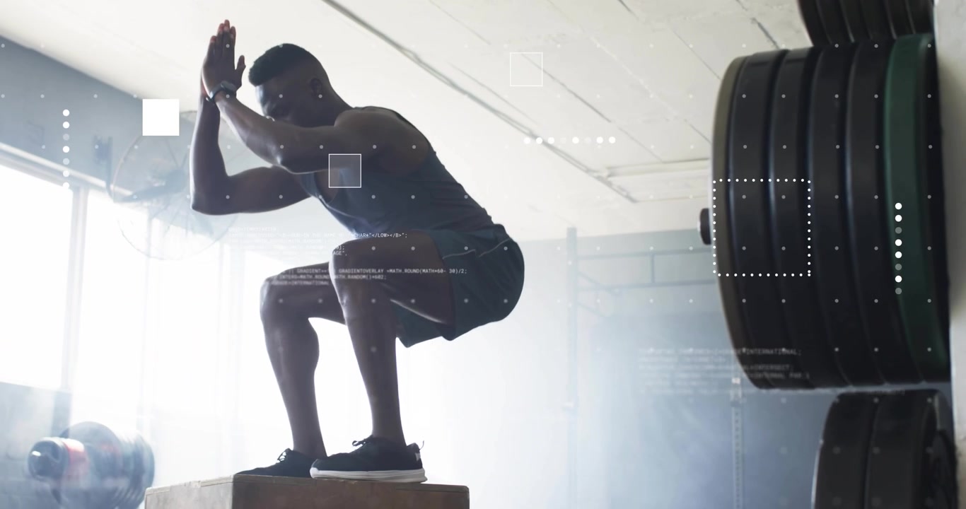 Male athlete shifting into squat, jumping onto plyometric box, landing near gym windows for fitness