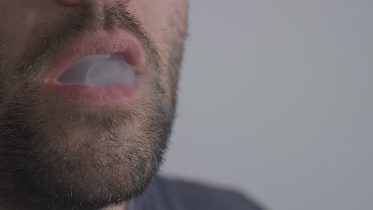 un hombre que usa una pluma de vape que inhala cannabis con nicotina o cbd con sabor