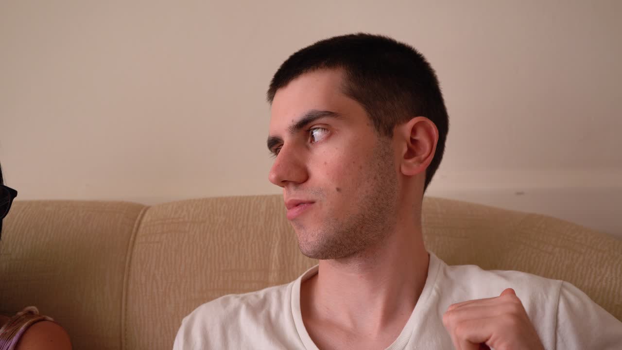 집에서 소파에 앉아 이야기하는 젊은 남자