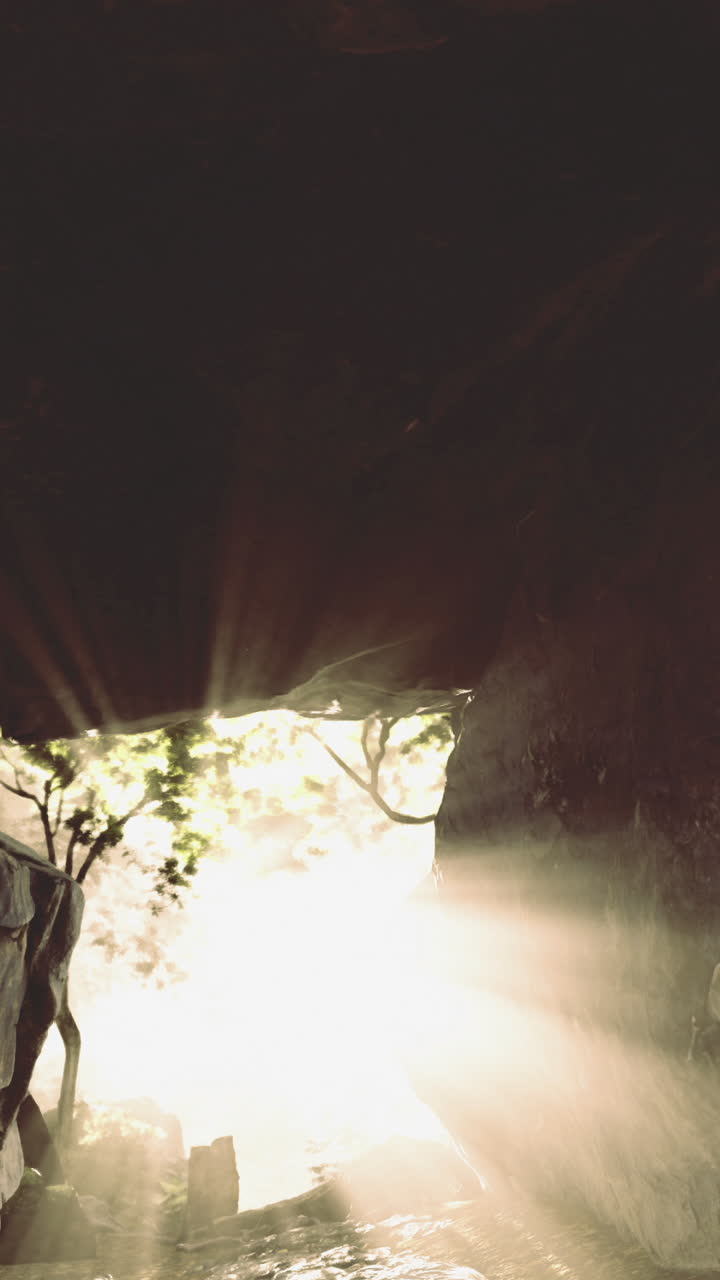 Raios de sol penetrando por uma entrada de caverna rochosa em uma floresta serena