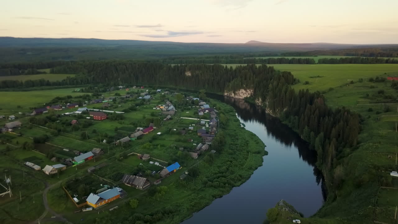 Vista aerea di un villaggio rurale in riva a un fiume al tramonto