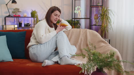 happy excited woman enjoying mobile smartphone loudspeaker talking good news, laughing on home sofa