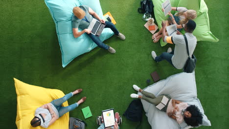 students using technology and sitting on bean bags