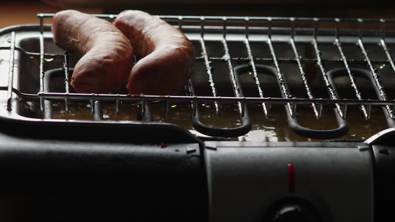 salchichas alemanas frescas untadas en una parrilla eléctrica puesta con pinzas cocina ecológica verde combate el calentamiento global bratwurst rostbratwurst tradicional deliciosa sabrosa cocina bávara caprichosa