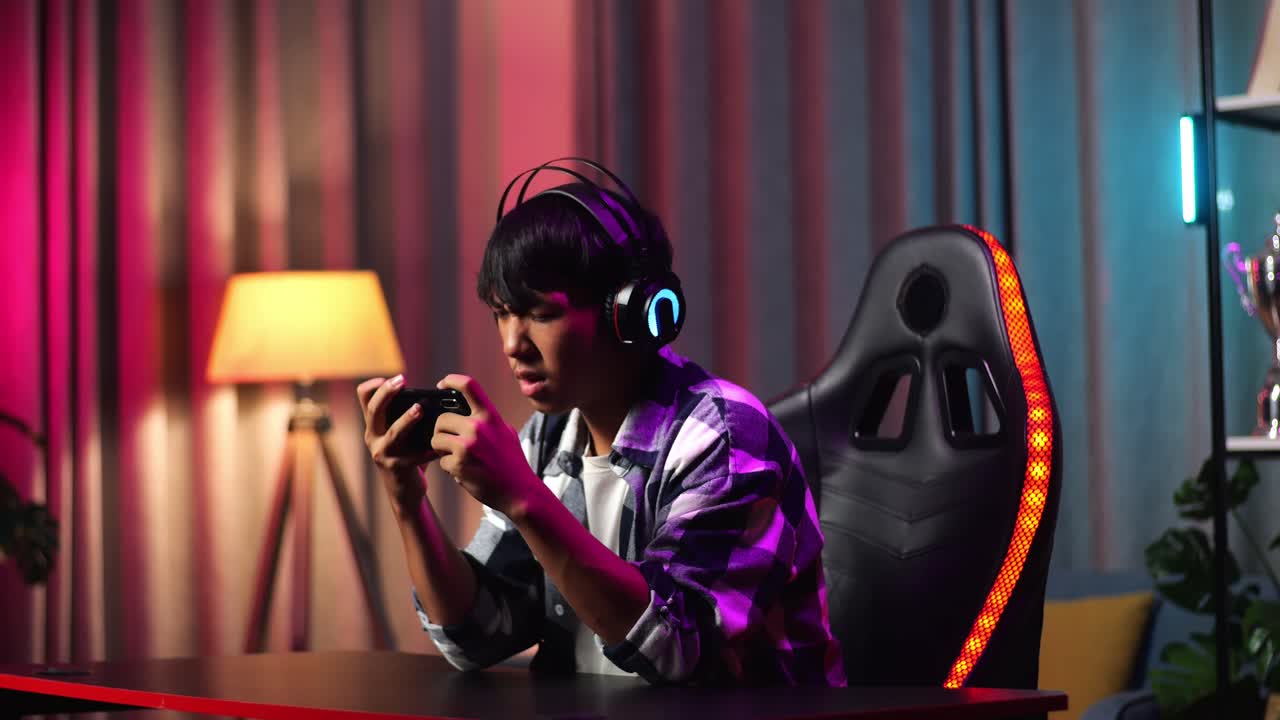 Gamer adolescente asiatico che perde mentre gioca a un videogioco sullo smartphone.