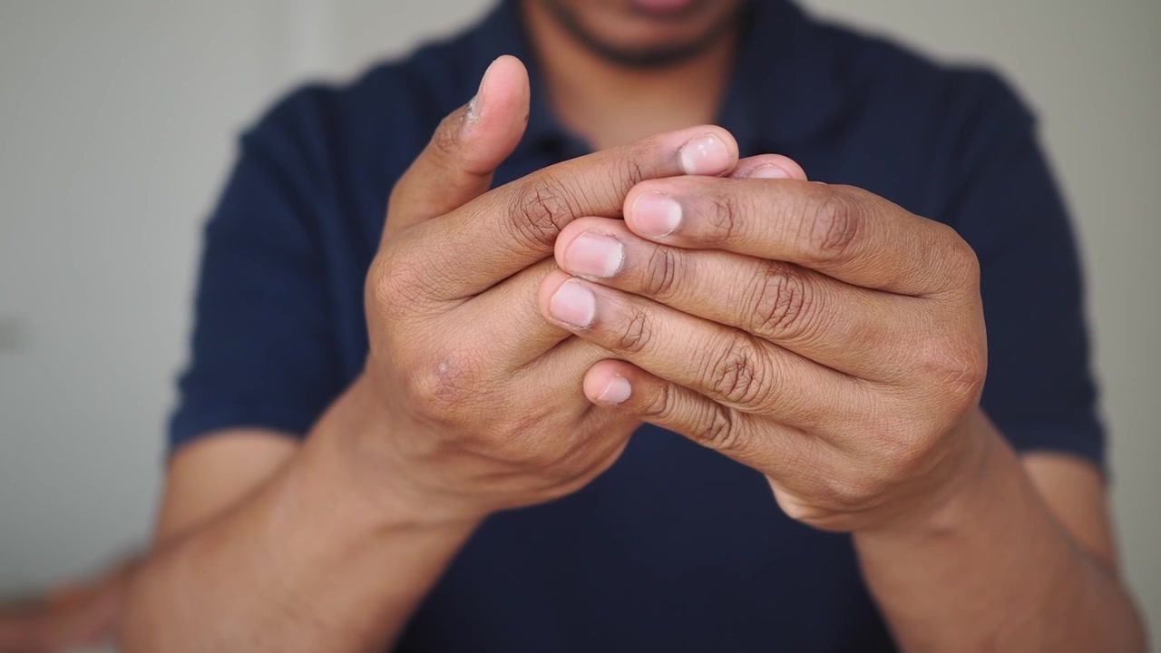 Pessoa massageando dedos e mãos doloridos para alívio da dor
