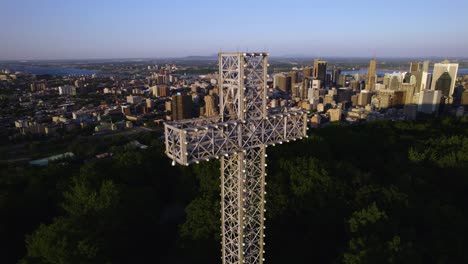 Drohnenaufnahme-Umkreist-Das-Croix-Du-Mont-Royal-Mit-Der-Skyline-Von-Montreal-Im-Hintergrund