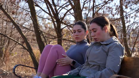 two women resting on a bench during a running session