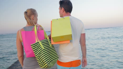una pareja de jóvenes amigables caminando por el muelle después de comprar.