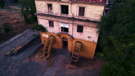 aerial view dolly out tilt up of the laboratory of the ex maternity building forgotten in the barros luco hospital in santiago chile with the sunset in the background - accordion-shaped entrance