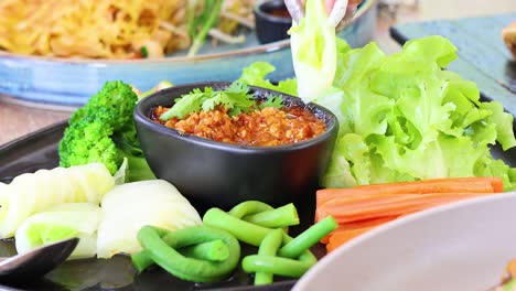 assembling a thai chili dip with vegetables