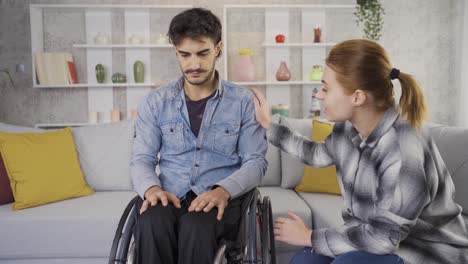 Disabled-male-man-in-wheelchair-chatting-with-friend-at-home.