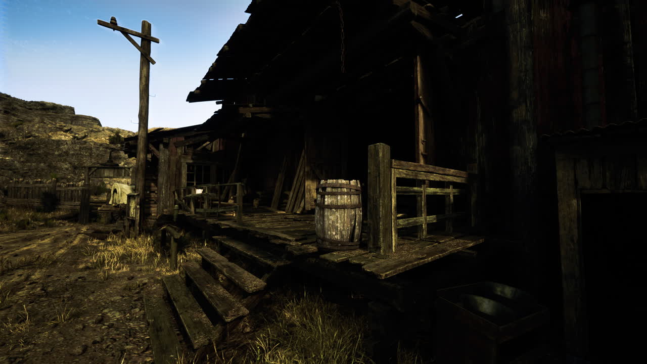 Old wooden building in a rural setting with overgrown pathways and barrels