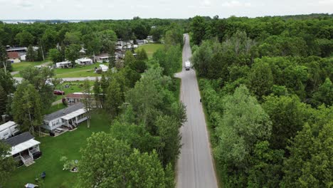 panoramic aerial view of a road in a countryside with lush tree forest