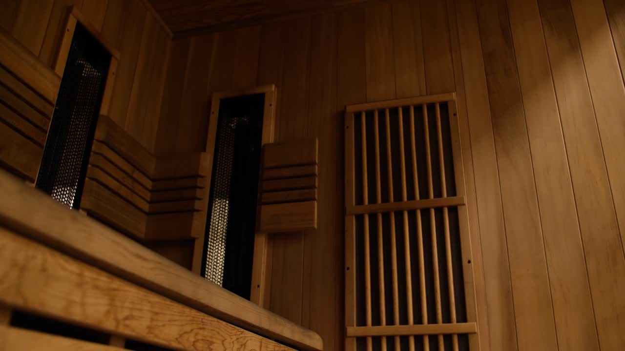 A slow gimbal push-out shot revealing the serene and warm wooden interior of a modern sauna