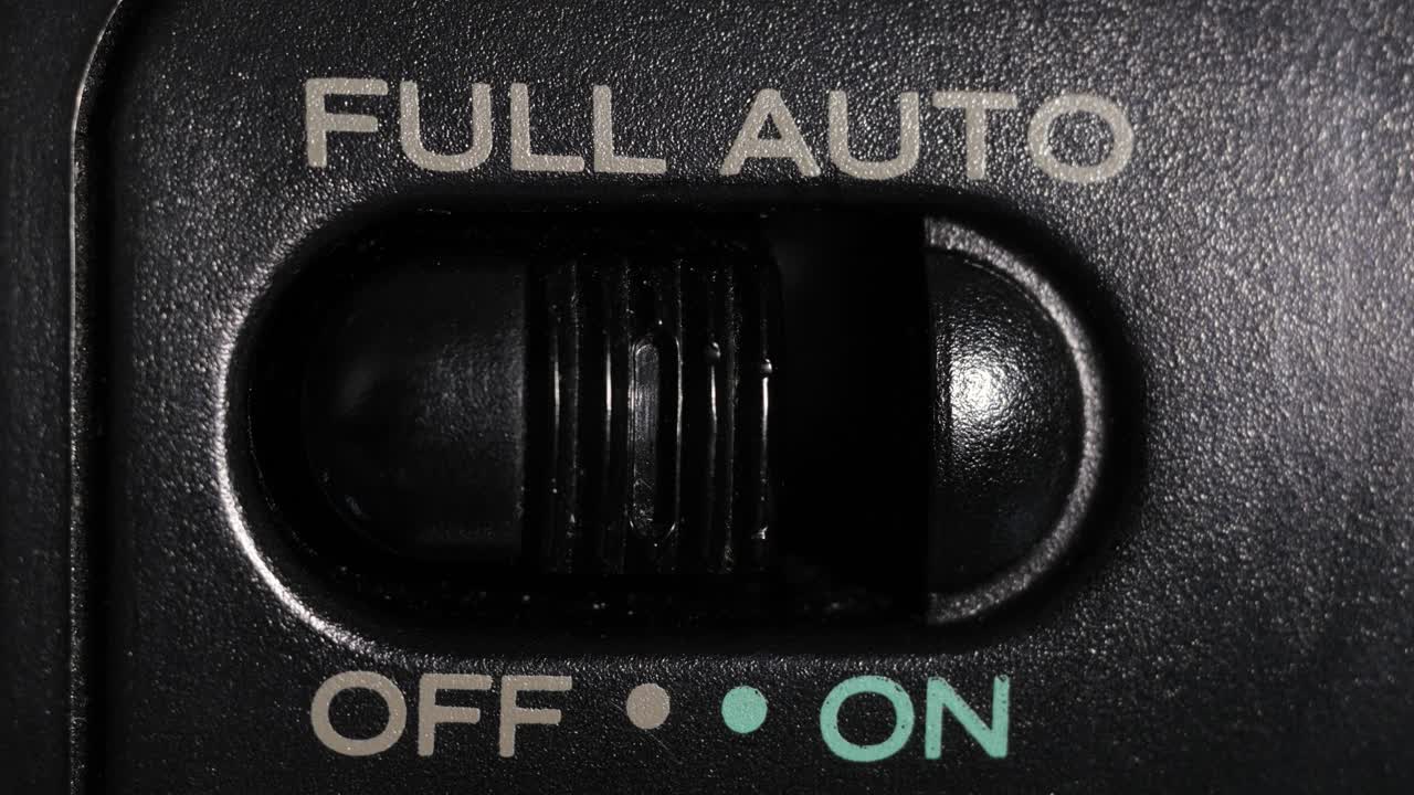 Macro close up of full auto switch sliding off to on, symbolizing automation and autopilot