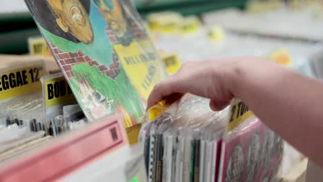 person flipping through vinyl records in market