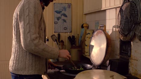 Smiling-man-cooking-food-in-kitchen