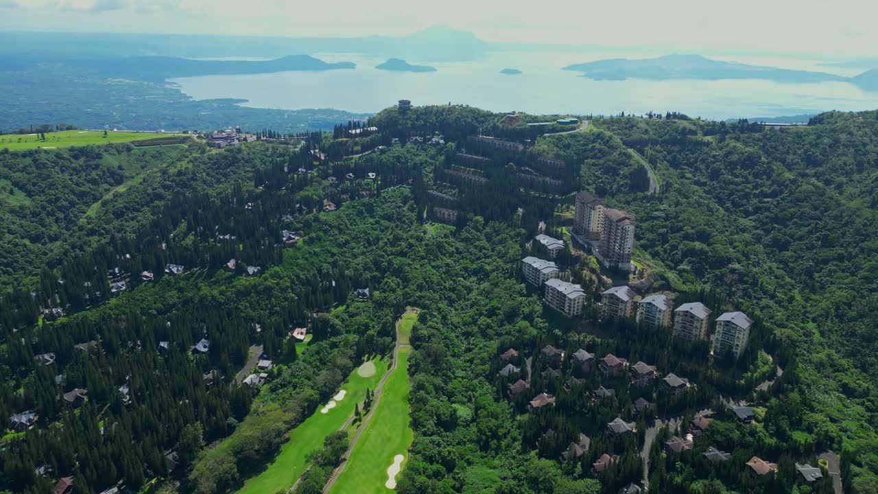A wide aerial view of The Woodlands Tagaytay Highlands showing pine trees, hillside homes, and forested terrain in Batangas, Philippines