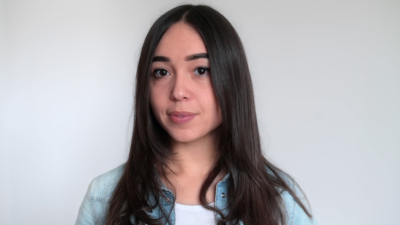 Girl is showing a flacon. Smiling. White background