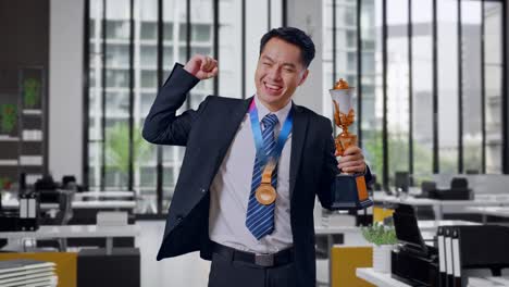 businessman celebrating achievement with trophy