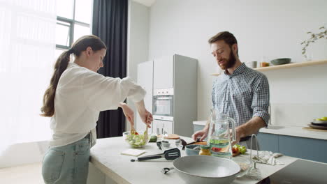 pareja joven hablando y preparando comida juntos en una cocina moderna