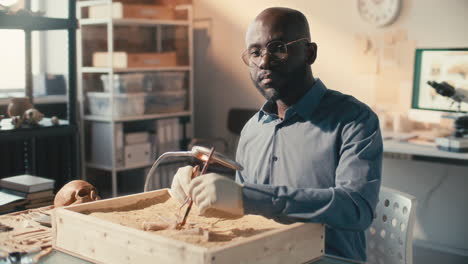 portrait of black archaeologist working with excavation tools in laboratory