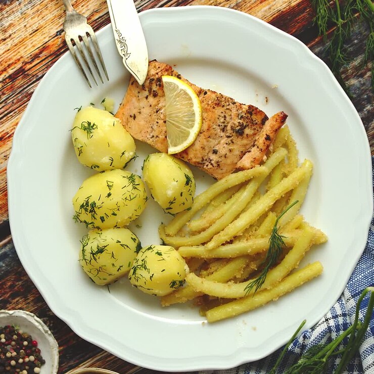 Salmón al horno fresco y sabroso, servido con patatas nuevas cocidas y judías amarillas