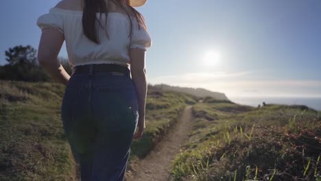mujer caminando por el verde campo de hierba