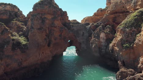 arcos rocosos naturales en la escarpada costa de lagos, en algarve, portugal - toma aérea sobrevuelo a nivel del suelo