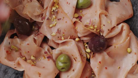ham italian mordatella, man slices of traditional italian antipasti mortadella sausage on a wooden cutting board, close up macro of chicken or turkey jamon, fat breakfast dish.
