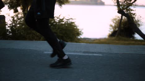 side tracking shot with legs of a man running early in the morning on the seafront