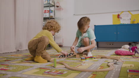 two little boys playing with wooden cars on the carpet in classroom in a montessori school 1