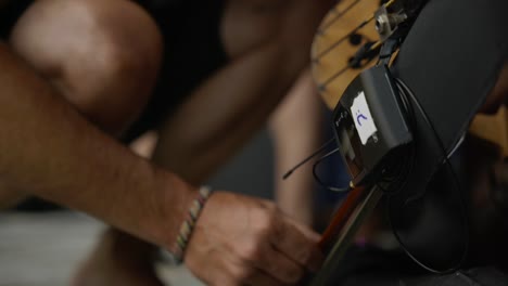 ingeniero de sonido colocando un pequeño equipo de audio negro in situ para su uso