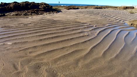 As-the-tide-goes-out-it-leaves-ridges-of-sand-where-the-water-flows-back-to-the-shore,-Puerto-Peñasco,-Gulf-of-California,-Mexico