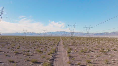 Desert-Road-Leading-to-Distant-Power-Transmission-Towers
