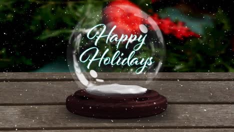 Animation-of-happy-holidays-text-in-snow-globe-on-wooden-table