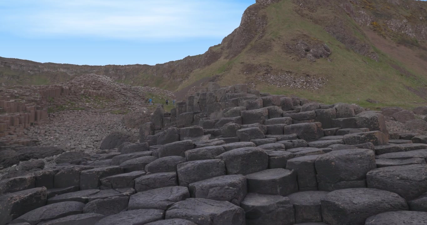 Basalt rotsformaties die door toeristen worden verkend bij de Giant's Causeway.
