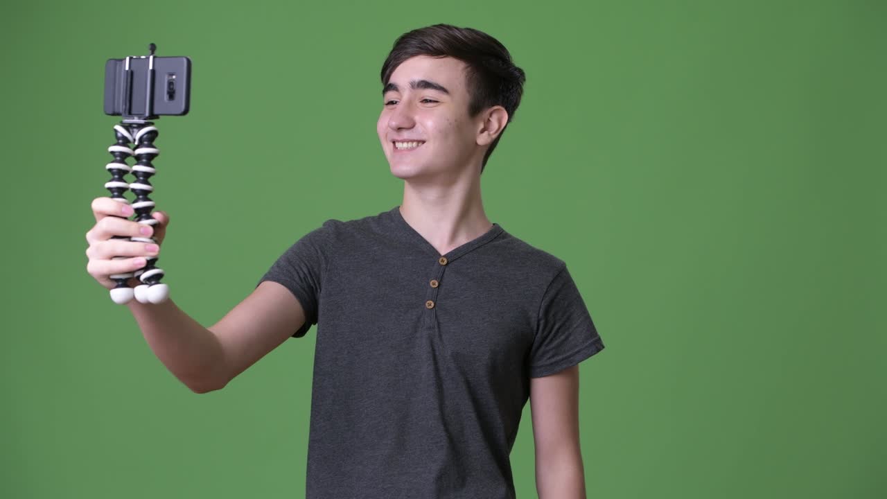 초록색 배경에 젊은 잘생긴 이란 십대 소년